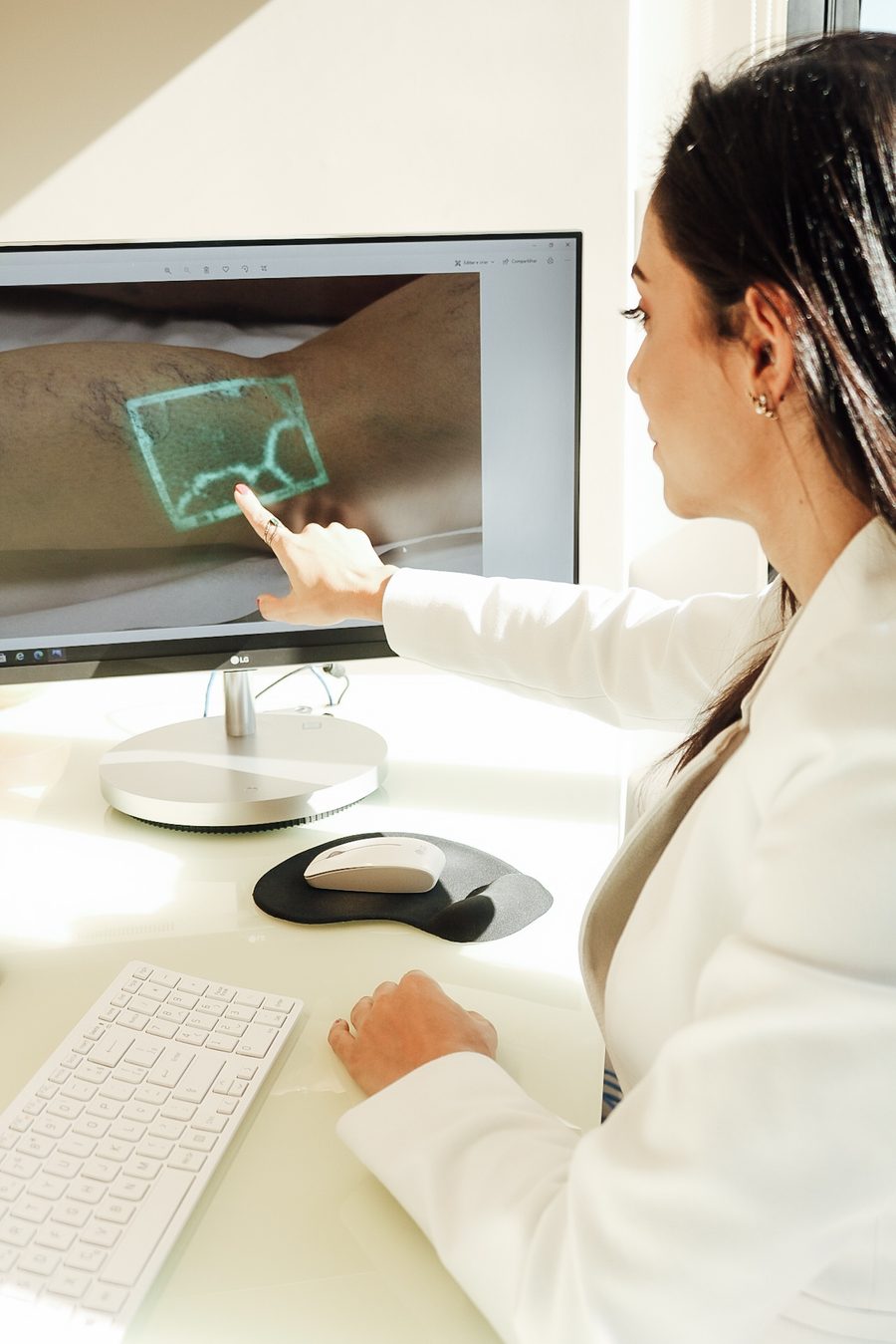 Dra. Aline Lamaita apontando para monitor com imagem vascular em realidade aumentada